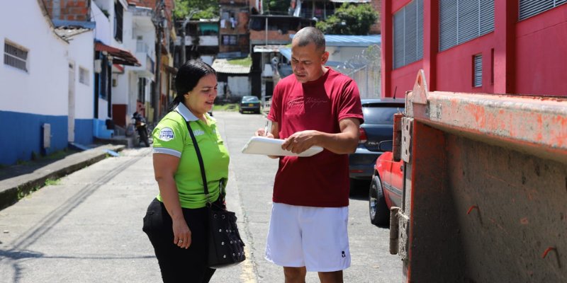 Promotora de la Empresa de Aseo de Pereira registra a un vecino que lleva inservibles a la caja estacionaria