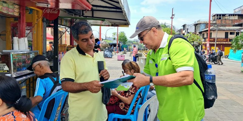 Promotor de la Empresa de Aseo de Pereira entrega material informativo a un ciudadano en el parque Guadalupe Zapata